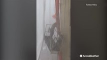 Workers cling desperately to platform attached to building as storm whips them around