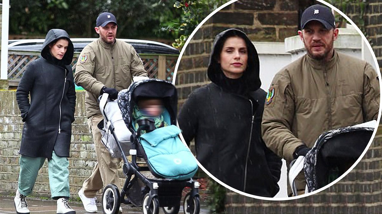Tom Hardy braves the wet weather in padded bomber jacket as he enjoys a family stroll with wife Charlotte Riley and their first child.