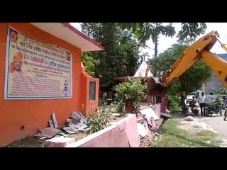 JCB runs on the wall of the temple built by encroachment