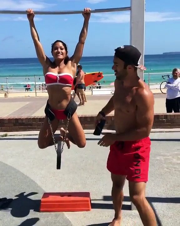 Musclée elle fait des tractions avec un poids au bord de la plage... tranquille !