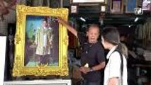 Thai citizens honour their late King by framing his portrait