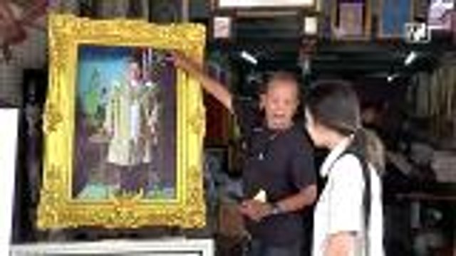 Thai citizens honour their late King by framing his portrait