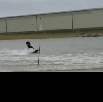 Man Surfs a Flooded Parking Lot in Shipshewana, Indiana