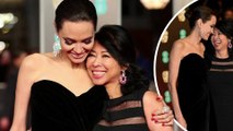 Jovial Angelina Jolie cosies up to human rights activist and First They Killed My Father author Loung Ung on the BAFTAs red carpet.