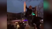 An Iranian policeman assaults a woman