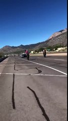 Policía apunta con una pistola a un motociclista haciendo caballitos