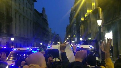 Un grup de manifestants seu a terra i canta els Segadors a l'inici de la Via Laietana