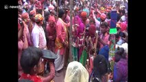Women thrash men with sticks to kick off colourful Holi festival in India