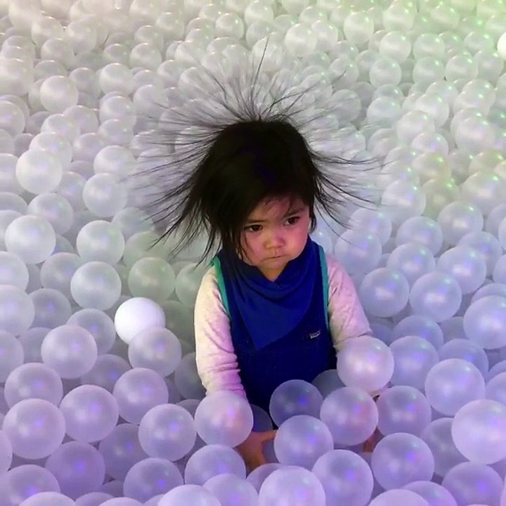 Niña en un pelotero y con los pelos erizados.....
