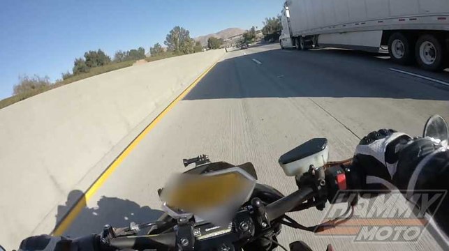 Un motard glisse sous la remorque d'un camion