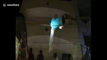 Man rescued after he dangles dangerously from overhead power lines