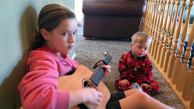 Elle joue de la guitare pour son petit frère trisomique