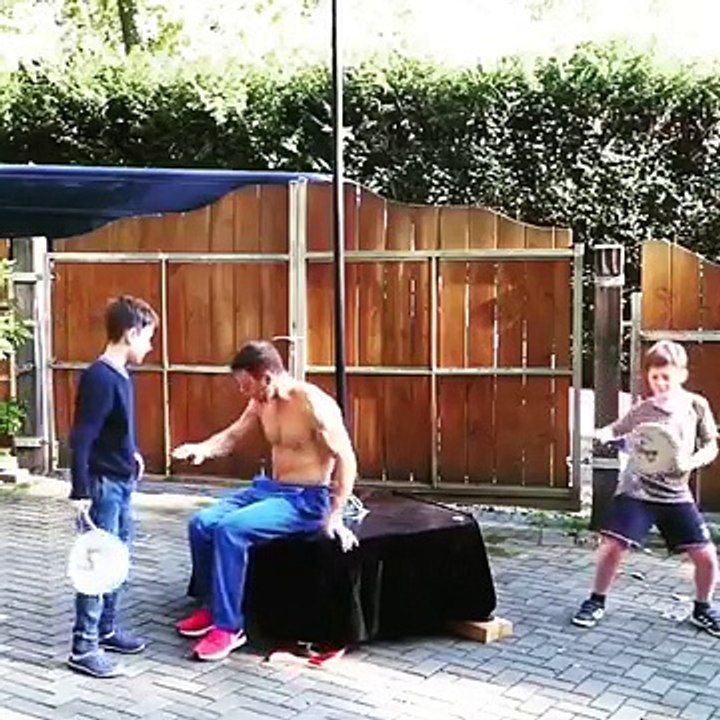 Deux enfants jouent avec papa qui fait le drapeau humain