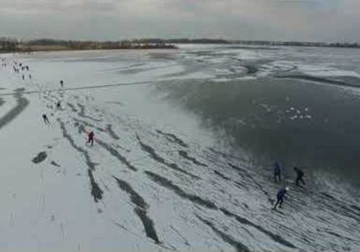 Ice Skaters Glide Across Frozen Dutch Lake