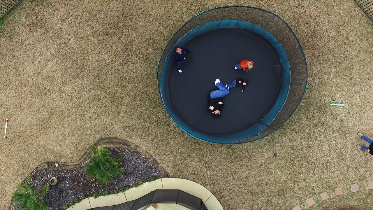 Drone above kids playing on a trampoline.