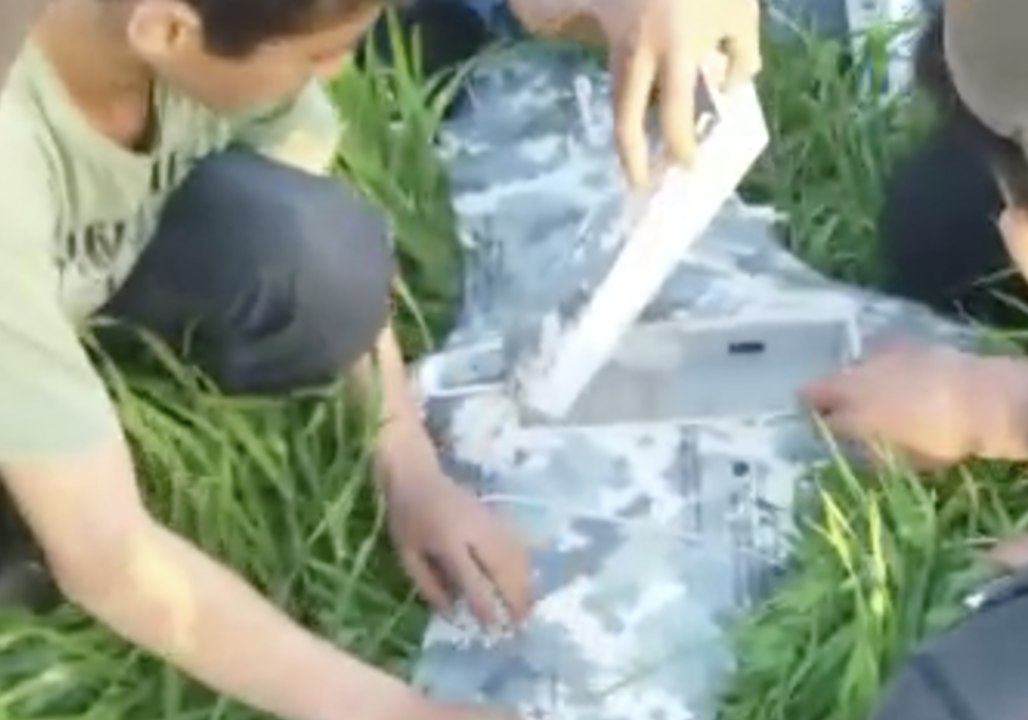 Kids Help Remove a Battery From Drone With Russian Writing Downed Near Frontline in Hama