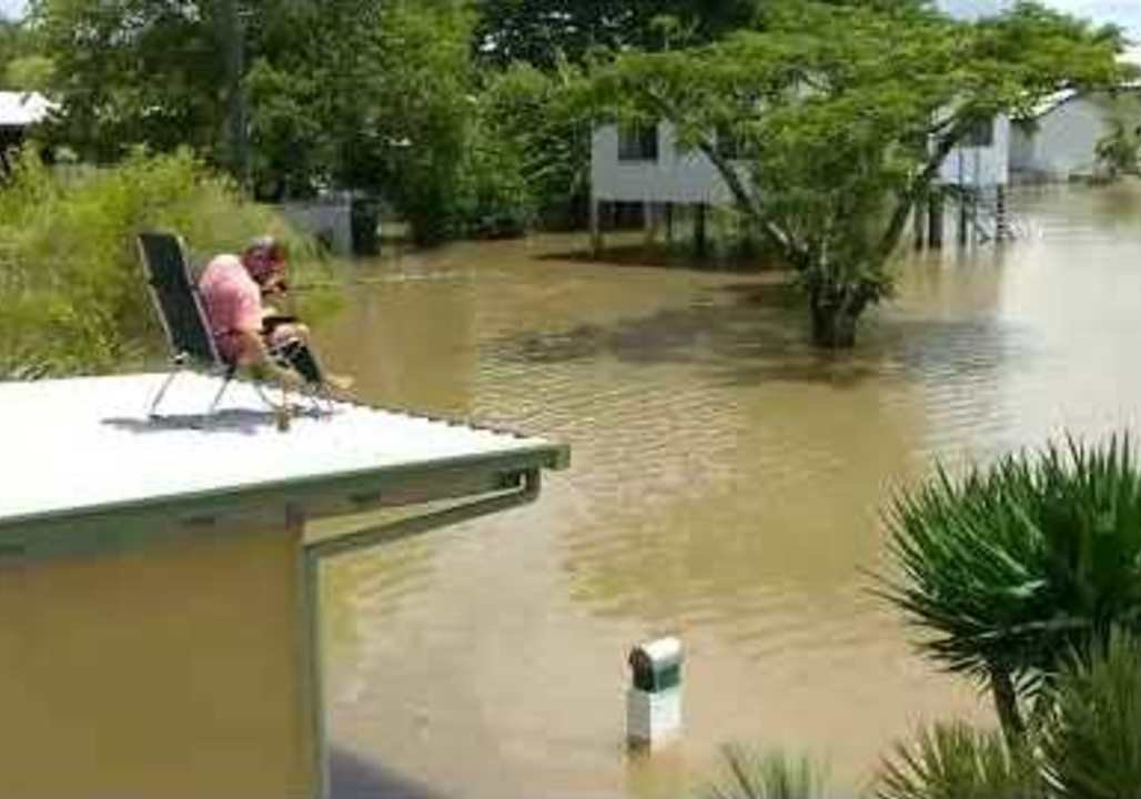 Ingham Man Drinks a Beer While Casually Fishing From His Roof in Floodwaters