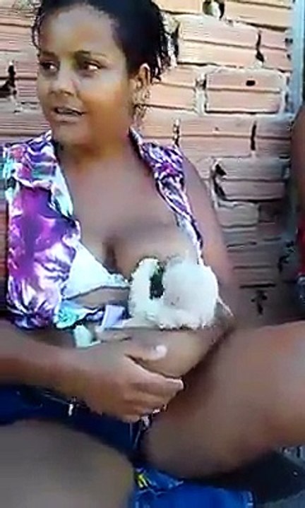 Mujer dando de mamantar a un perrito