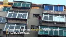 Firefighters rescue man dangling from top of building in northeast China