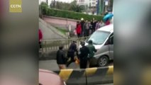 Pedestrians push against sliding car to save faint woman in S China