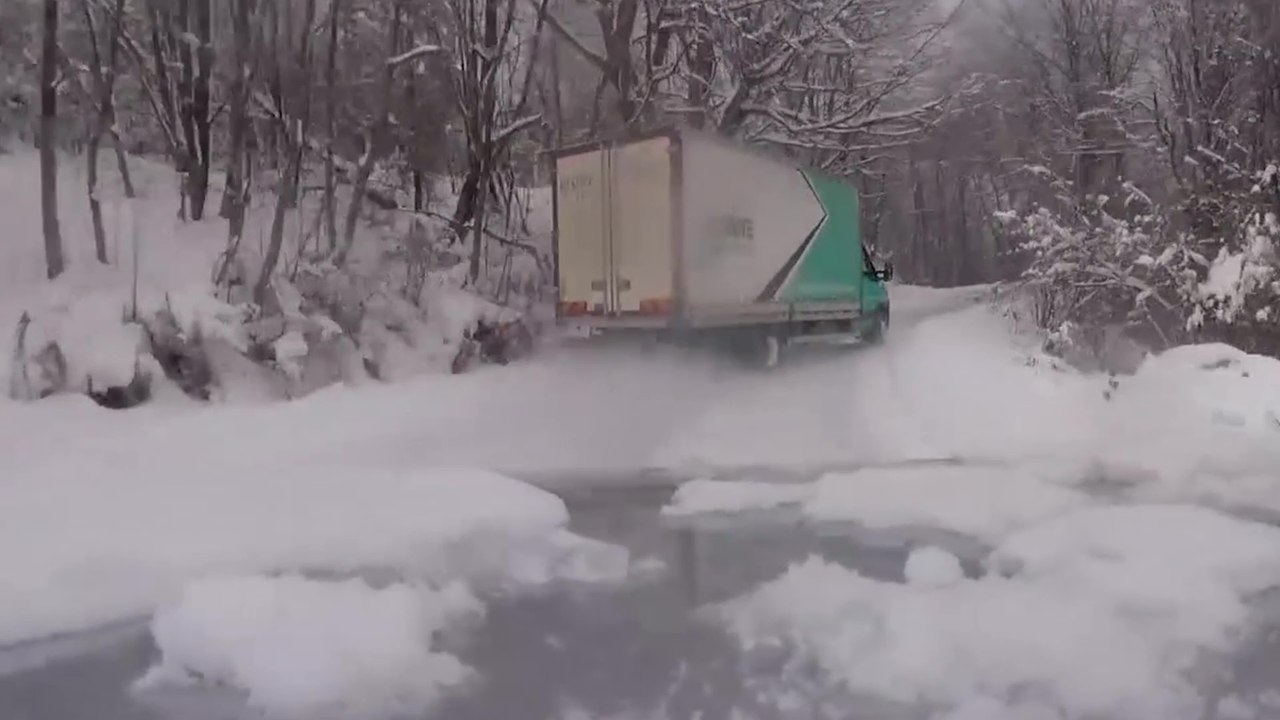 Un chauffeur met son camion en travers dans chaque virage sur une route de montagne enneigée