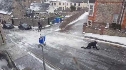 Des passants tentent de remonter une rue verglacée
