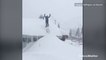 Thrill seeker skis off roof into deep powder of snow