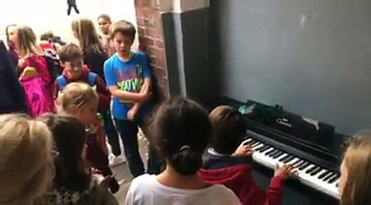 Un élève joue spontanément au piano dans la cour de l'école