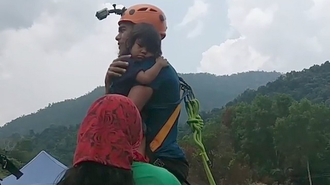 Il fait un saut pendulaire avec sa fille de 2 ans qu'il tient seulement dans les bras