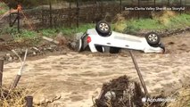 Raging floodwaters push vehicle into gully