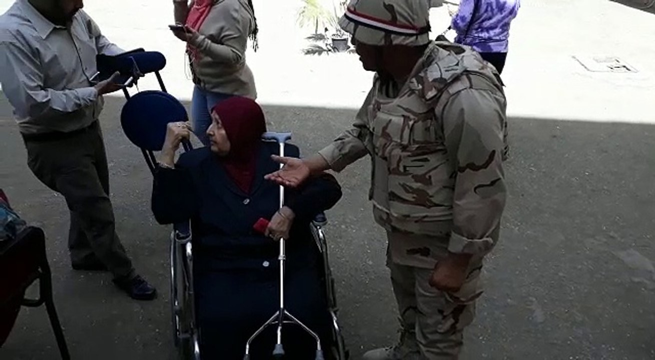 مسنة تدلي بصوتها على كرسي متحرك