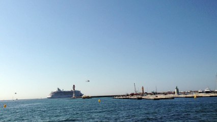 Helicopter landing at the Cannes Marina, next to a cruise ship. Private Travel.