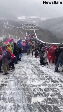 Ces touristes n'arrivent pas à grimper la grande muraille de Chine couverte de neige