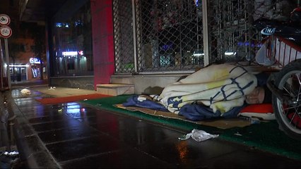 Yağmur altında uyumaya çalışan yaşlı adam yürekleri sızlattı