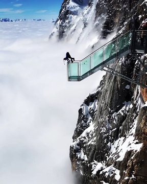Une femme fait sa gym sur un spot magnifiquement dangereux au dessus des nuages