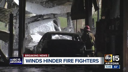 Скачать видео: Winds hinder firefighters battling building fire in Phoenix