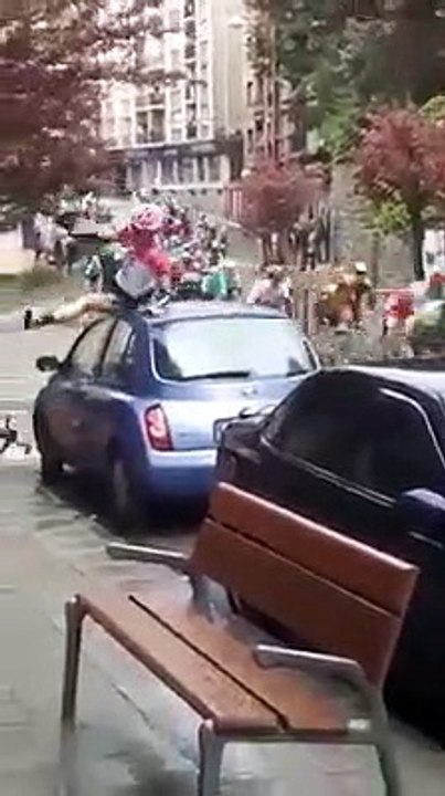 Un cycliste prend un peu large dans un virage en descente pendant une course