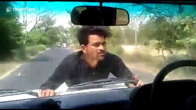 Angry protester clings to official's SUV bonnet for 4km