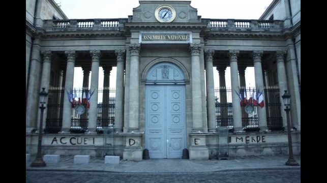 Contre la loi Asile, ces militants écrivent accueil de merde à la mousse au chocolat sur la façade de l'AN