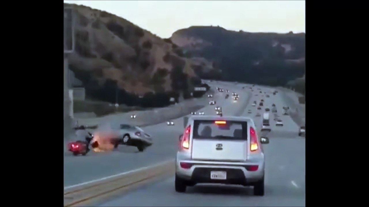 Un homme en moto donne un petit coup de pied à une voiture mais va provoquer un énorme accident