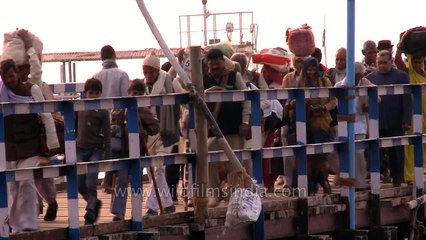Poor children stand in mangrove mud, with nets to collect coins in
