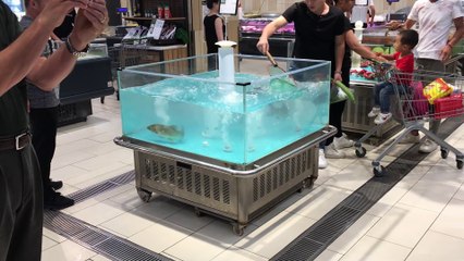 Un poisson saute directement dans le caddie d'un client... Aller, à table