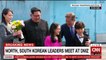 Kim and Moon shake hands on both sides of demarcation line