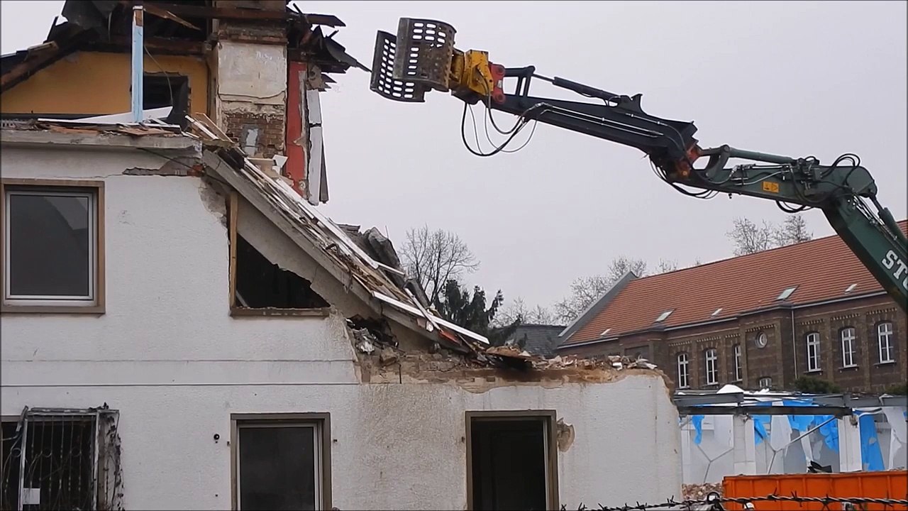 Bagger mit dem Abriss Greifer und jede Menge Staub Achtung Klassik