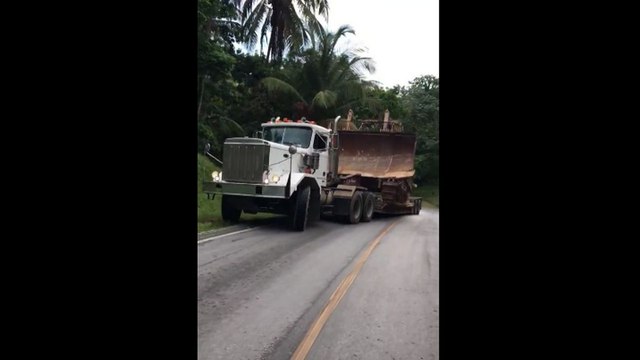 Un camion transportant un bulldozer glisse sur une colline