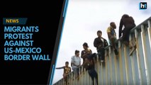 US and Mexico border fence issue intensifies as hundreds of migrants protest and scale wall