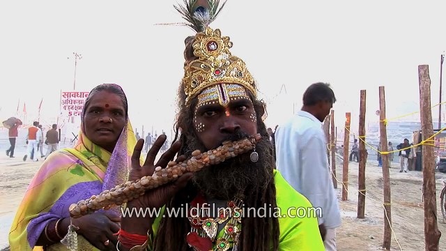 Sadhu with sea-shell embedded flute, others parade on camel to Ganges