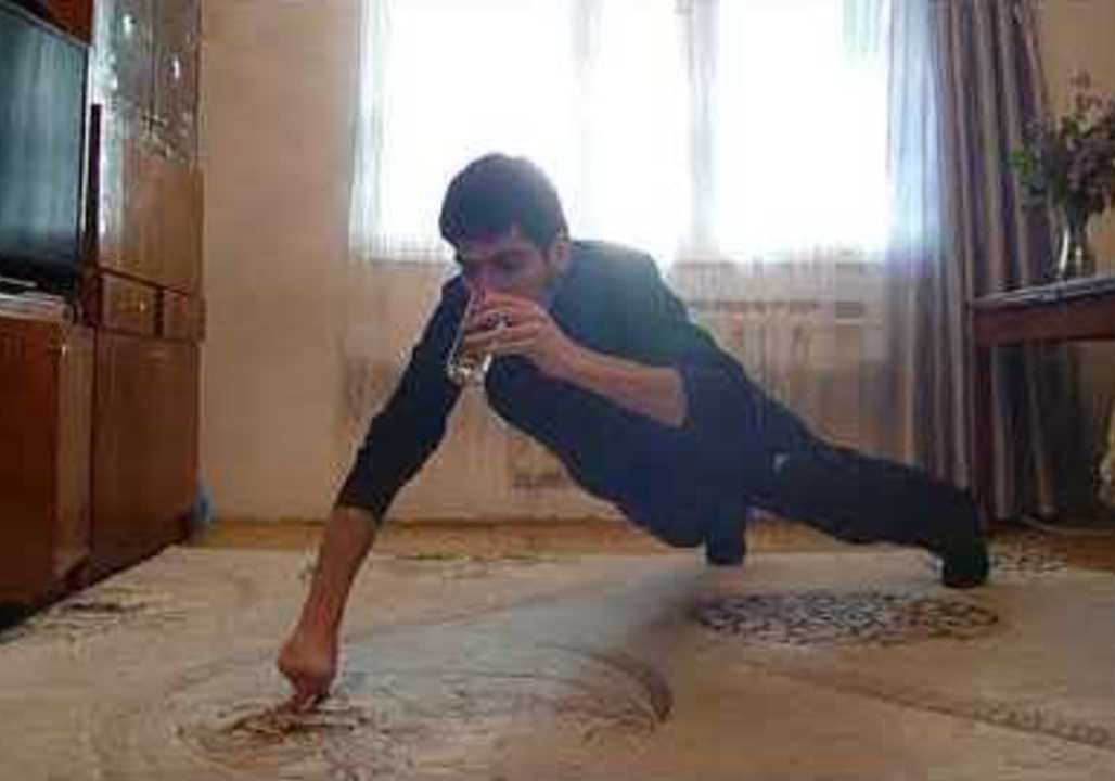 Man Performs Two-Finger Push-Ups While Drinking Water