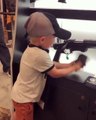 Un enfant recharge et tir sur un fusil d'assaut pour une démonstration
