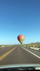 Hot Air Balloon Hovers Over Cars